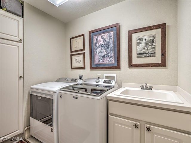 laundry room featuring sink, independent washer and dryer, cabinets, and a textured ceiling