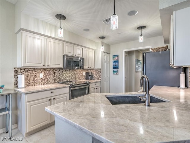 kitchen featuring pendant lighting, sink, white cabinetry, light stone countertops, and stainless steel appliances