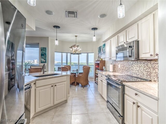 kitchen featuring sink, hanging light fixtures, white cabinets, and stainless steel appliances