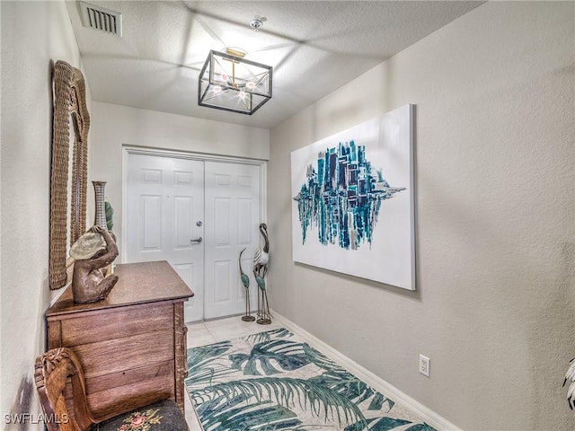 interior space with light tile patterned floors and a textured ceiling