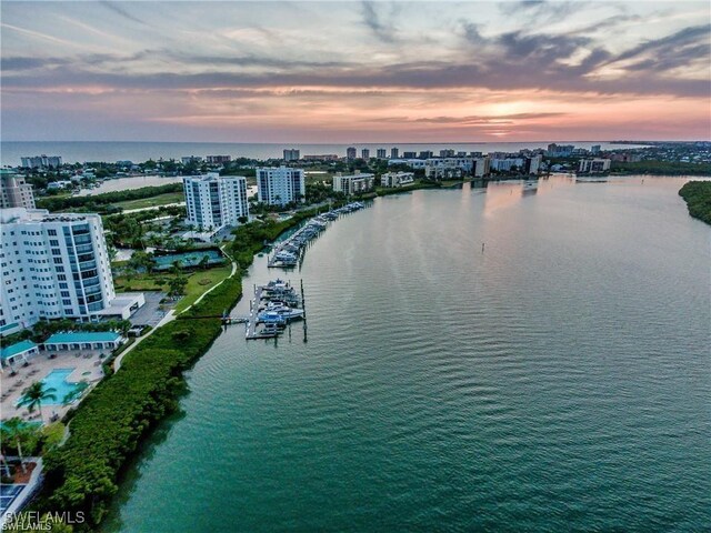 aerial view at dusk featuring a water view