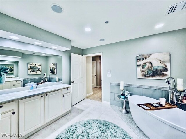 bathroom with vanity, a tub, and tile patterned floors