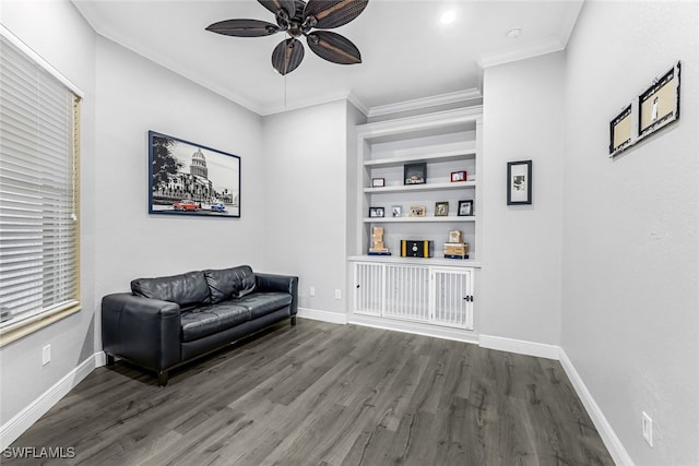 sitting room with built in shelves, ceiling fan, dark hardwood / wood-style flooring, and crown molding