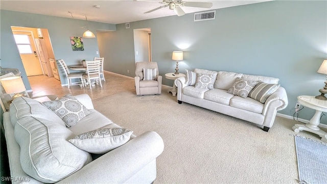 living area featuring visible vents, ceiling fan, light carpet, and baseboards