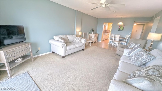 carpeted living room with ceiling fan