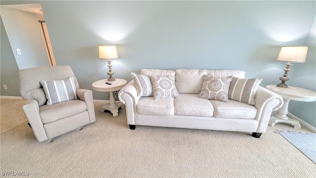 living area featuring light carpet and baseboards