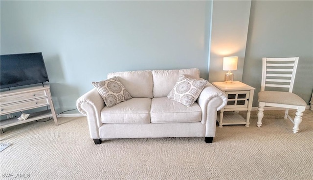 living area featuring carpet flooring and baseboards