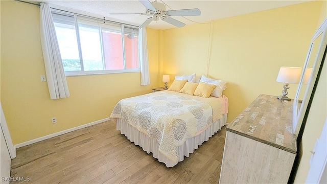 bedroom with light wood-type flooring, baseboards, and a ceiling fan