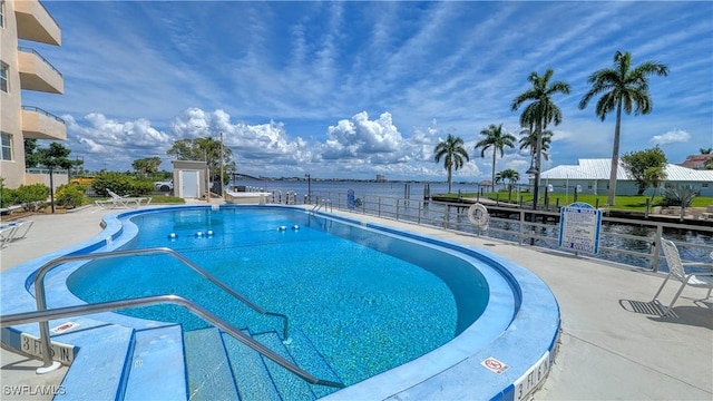 view of pool with a water view and a patio area