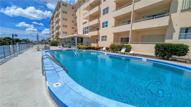 community pool featuring a patio area and fence