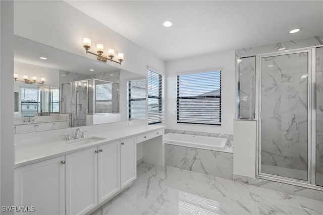 bathroom with vanity and shower with separate bathtub