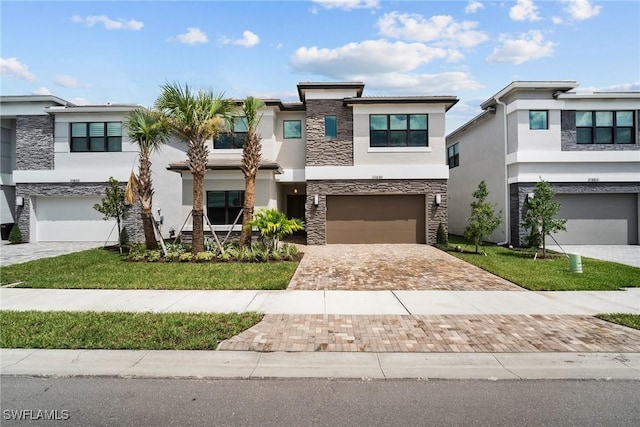 20849 Thistle Leaf Ln, Estero, FL 33928 - view of front of home with an attached garage, stucco siding, stone siding, and decorative driveway
