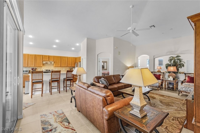 tiled living room with ceiling fan and vaulted ceiling