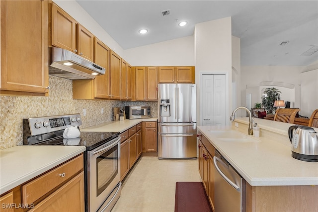 kitchen with stainless steel appliances, vaulted ceiling, sink, tasteful backsplash, and light tile patterned floors