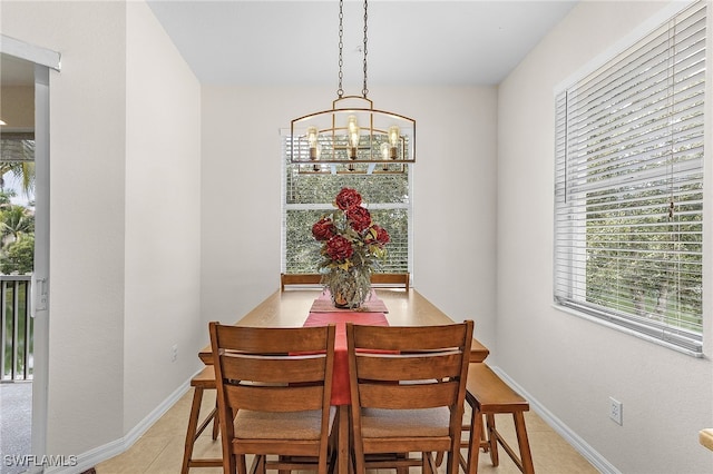 dining space featuring a chandelier, baseboards, and light tile patterned flooring