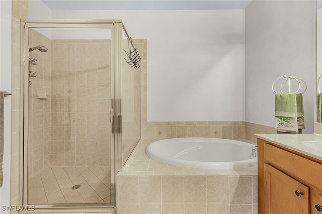 bathroom featuring a shower stall, a bath, and vanity