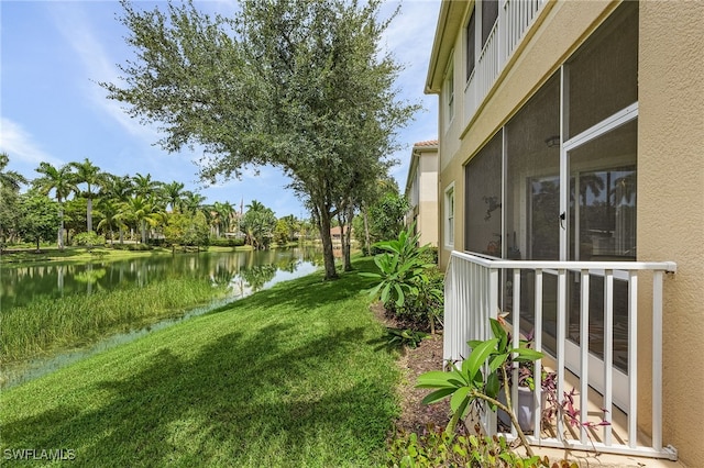 view of yard featuring a water view and a sunroom