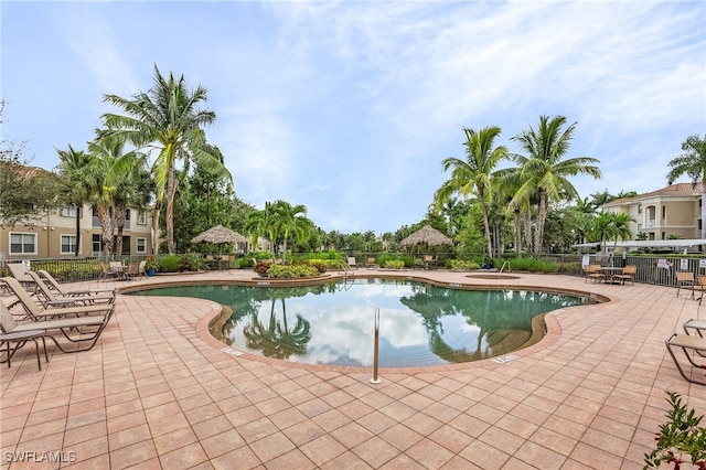 pool with a patio and fence