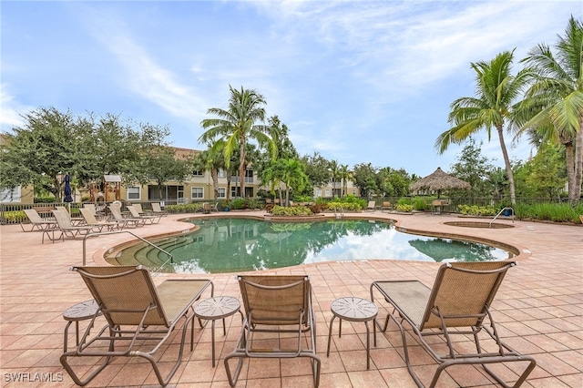 pool with a patio and fence