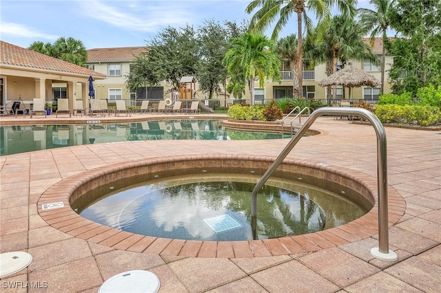 view of swimming pool with a community hot tub and a patio