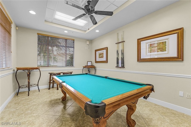 playroom featuring a ceiling fan, baseboards, a tray ceiling, tile patterned flooring, and a wealth of natural light