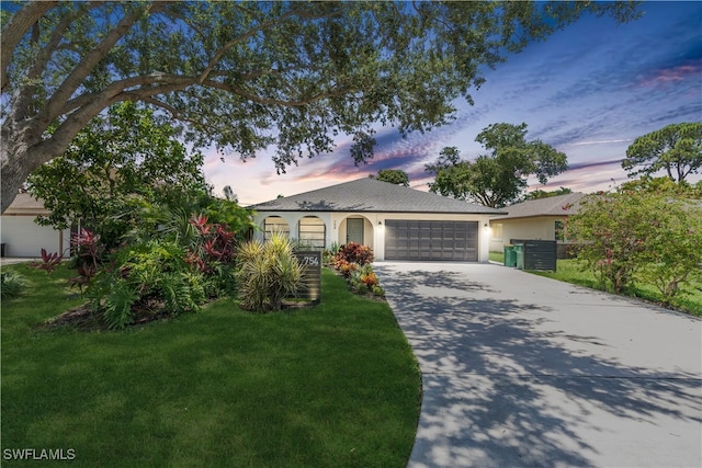 single story home featuring a yard and a garage