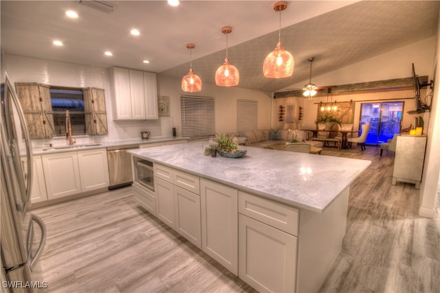 kitchen with white cabinets, appliances with stainless steel finishes, lofted ceiling, ceiling fan, and a kitchen island