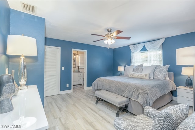 bedroom featuring light hardwood / wood-style floors, ceiling fan, and ensuite bathroom