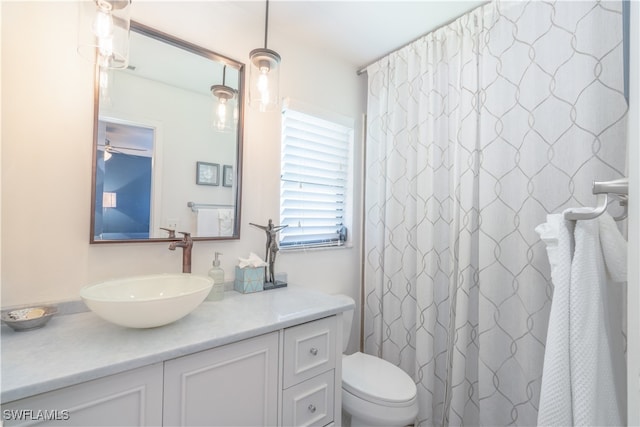 bathroom with vanity, toilet, a shower with curtain, and ceiling fan