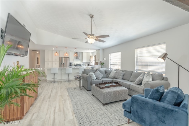 living room with light wood-type flooring, lofted ceiling, and ceiling fan