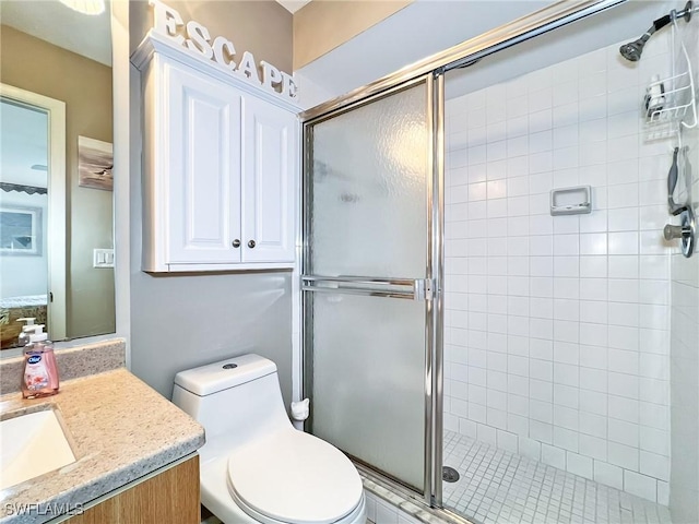 bathroom featuring a shower with door, vanity, and toilet