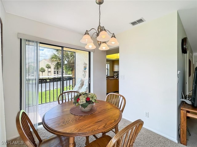 carpeted dining space with a chandelier