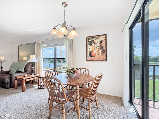 carpeted dining room featuring a notable chandelier