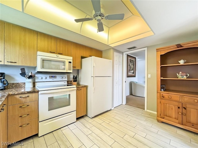 kitchen featuring white appliances, light hardwood / wood-style flooring, ceiling fan, and dark stone countertops