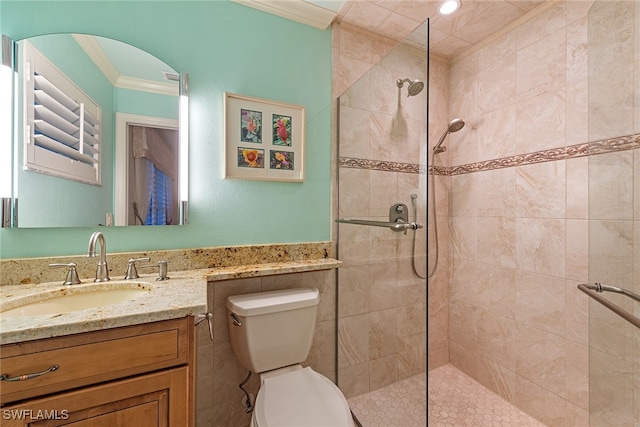 bathroom with ornamental molding, tiled shower, vanity, and toilet