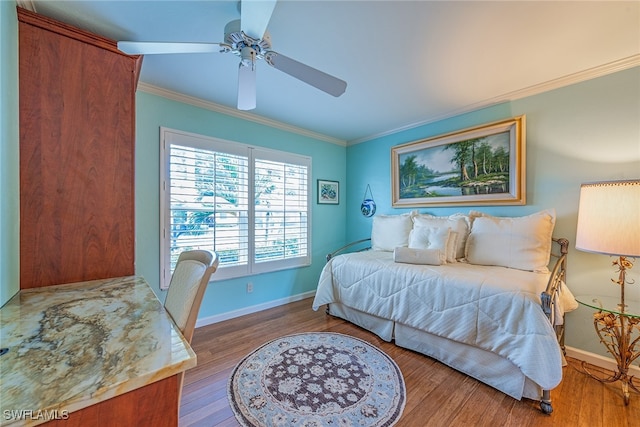 bedroom with ceiling fan, hardwood / wood-style floors, and crown molding