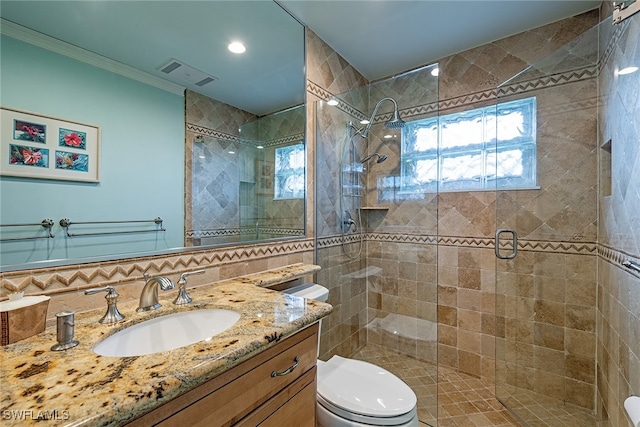 bathroom featuring a shower with door, vanity, and toilet