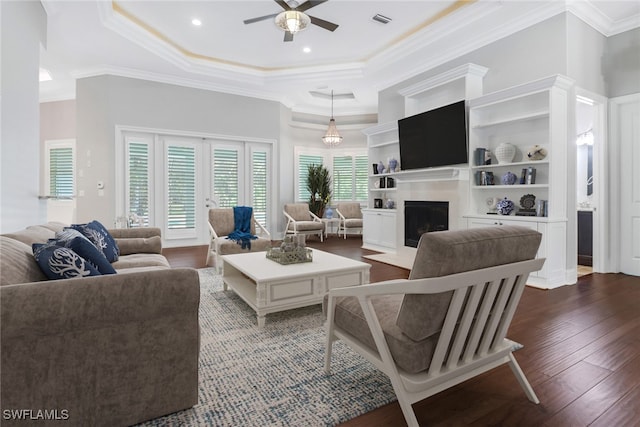 living room featuring ornamental molding, ceiling fan, a raised ceiling, and dark hardwood / wood-style flooring