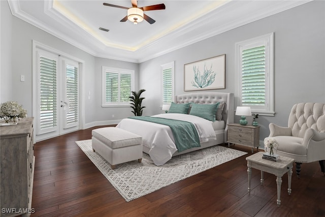 bedroom featuring ceiling fan, a raised ceiling, dark hardwood / wood-style floors, and access to exterior