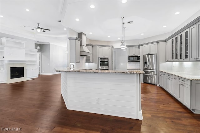 kitchen with custom exhaust hood, stainless steel appliances, dark wood-type flooring, and gray cabinetry