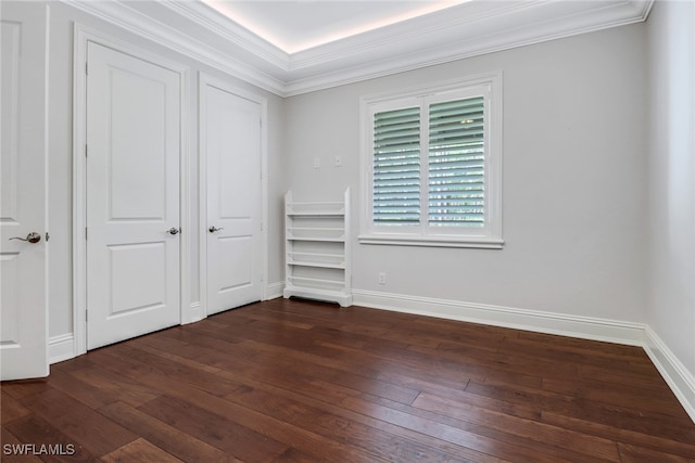 unfurnished bedroom featuring crown molding and dark hardwood / wood-style flooring