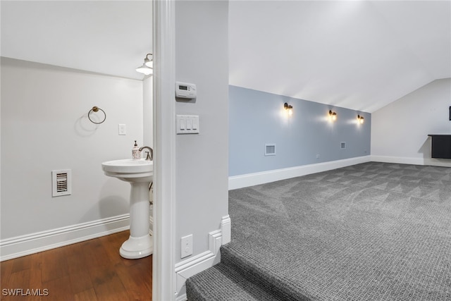 bathroom featuring lofted ceiling, sink, and hardwood / wood-style flooring