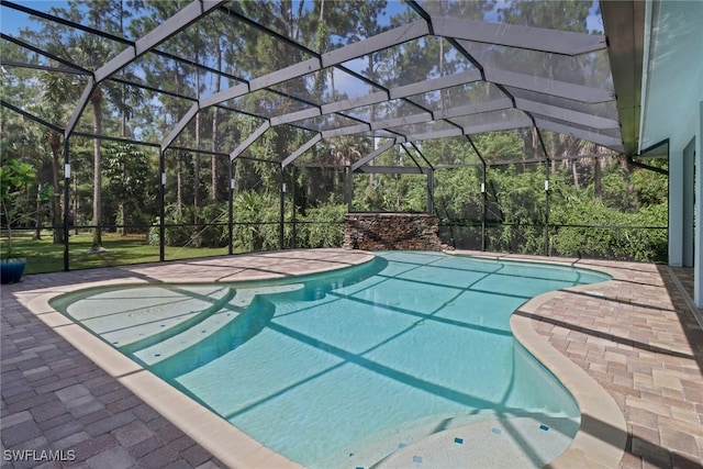 view of swimming pool featuring a patio and a lanai