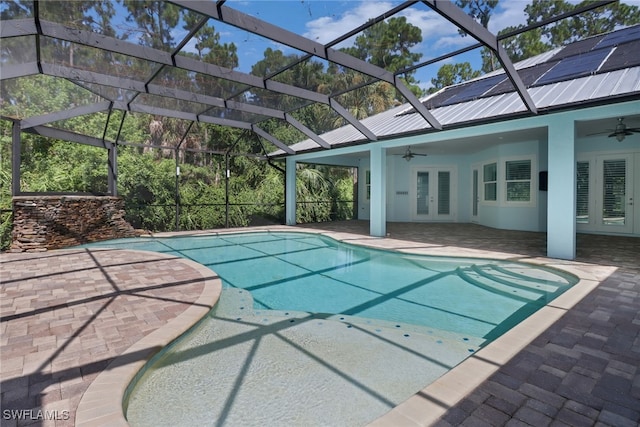 view of swimming pool featuring a patio, ceiling fan, and glass enclosure