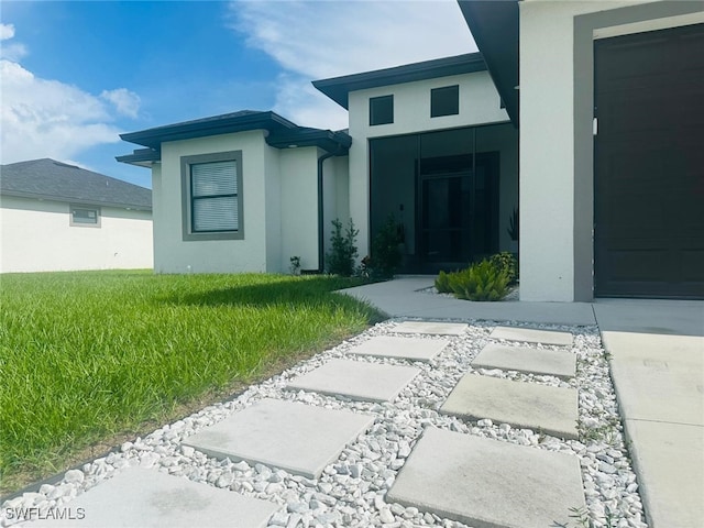 3713 25th St SW, Lehigh Acres, FL 33976 - entrance to property featuring a lawn and stucco siding