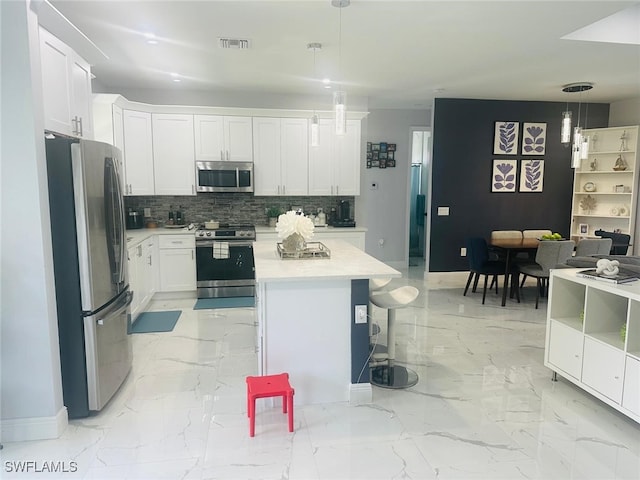 kitchen featuring appliances with stainless steel finishes, white cabinetry, a kitchen island, and pendant lighting