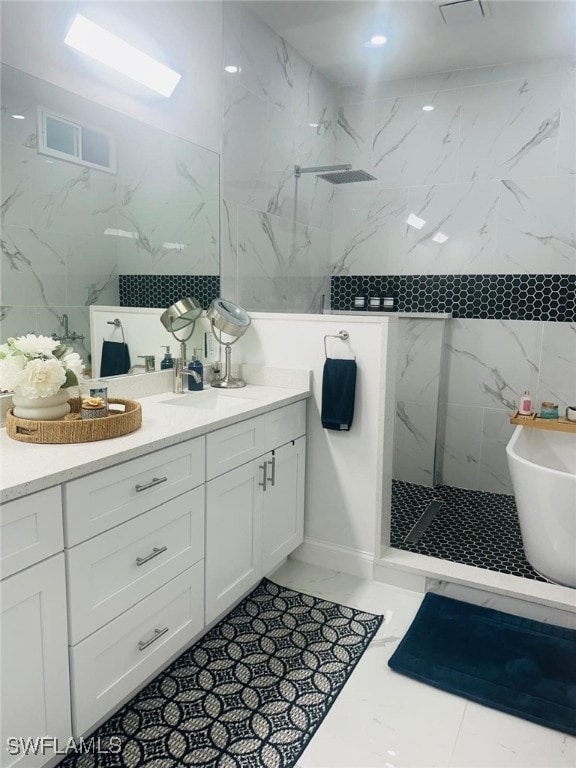 bathroom with vanity, tile walls, and independent shower and bath