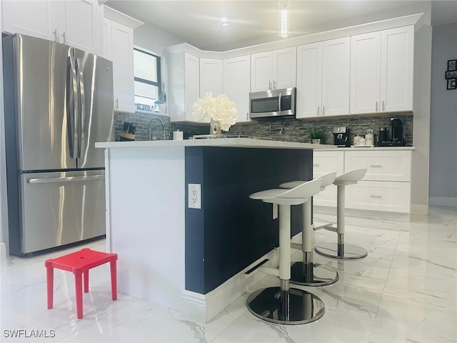 kitchen featuring light stone counters, appliances with stainless steel finishes, white cabinetry, and tasteful backsplash