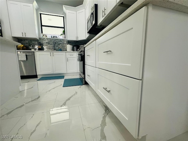 3713 25th St SW, Lehigh Acres, FL 33976 - kitchen with white cabinetry, decorative backsplash, a sink, stainless steel appliances, and marble finish floor
