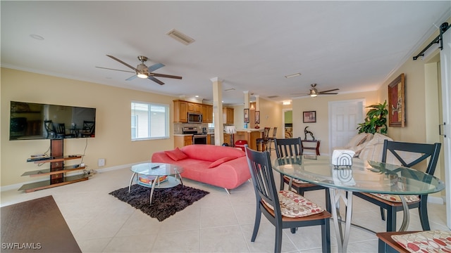 tiled living room featuring ceiling fan, ornamental molding, and a barn door